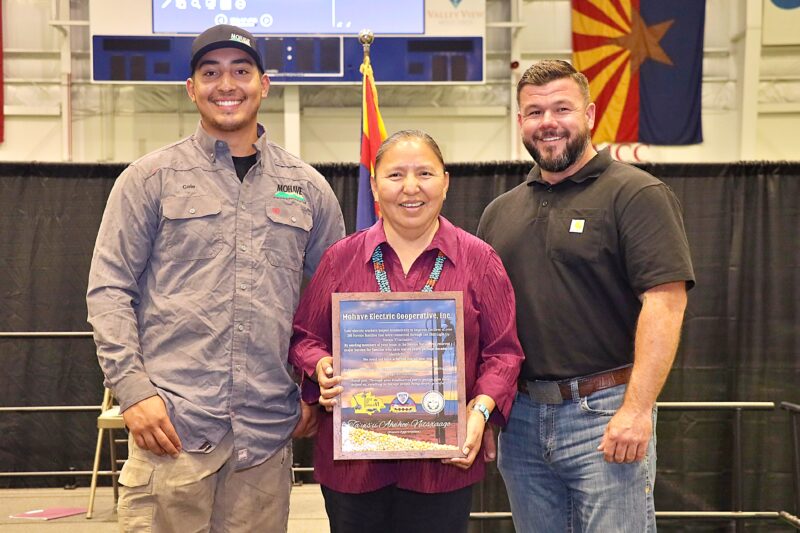 MEC Linemen Chad Valenzuela and Cole Garcia receive a Light Up Navajo plaque from Vircynthia Charley, representing the Navajo Tribal Utility Authority, Kayenta District.
